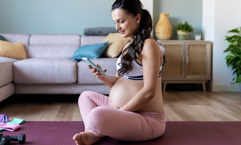 Pregnant Woman With Phone On Yoga Mat.jpeg