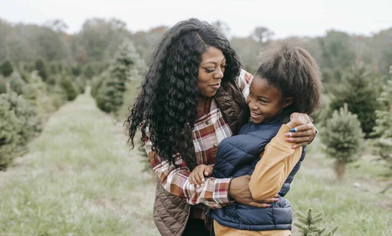 Cheerful African American Mum Cuddling Child While.jpeg