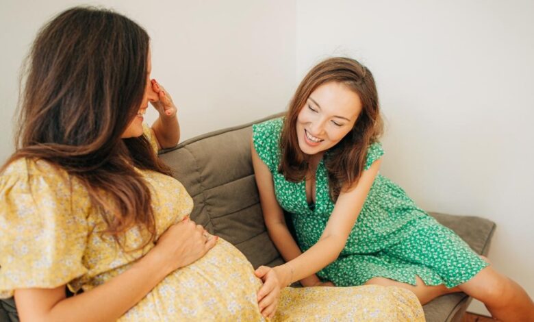 Woman Touching The Pregnant Belly Of Her Friend.jpeg